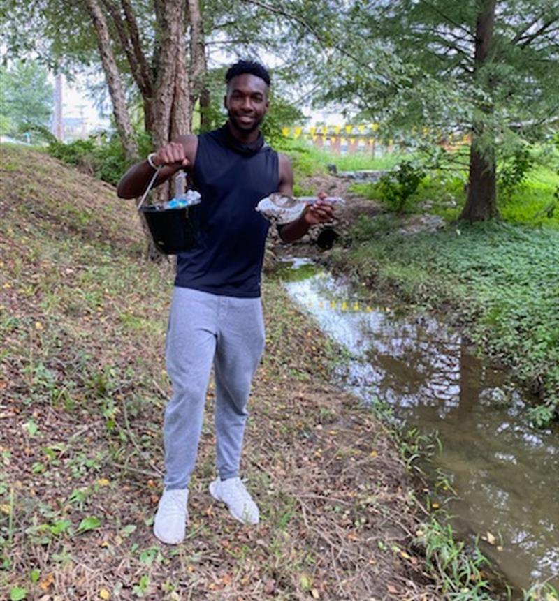 Intro to Microbiology student Joseph Nwobi shows off his sediment collection as he takes to the outdoors to complete his Winogradsky column. Photo courtesy Joseph Nwobi.
